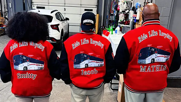 Barons Bus drivers in garage showing uniform jacket back